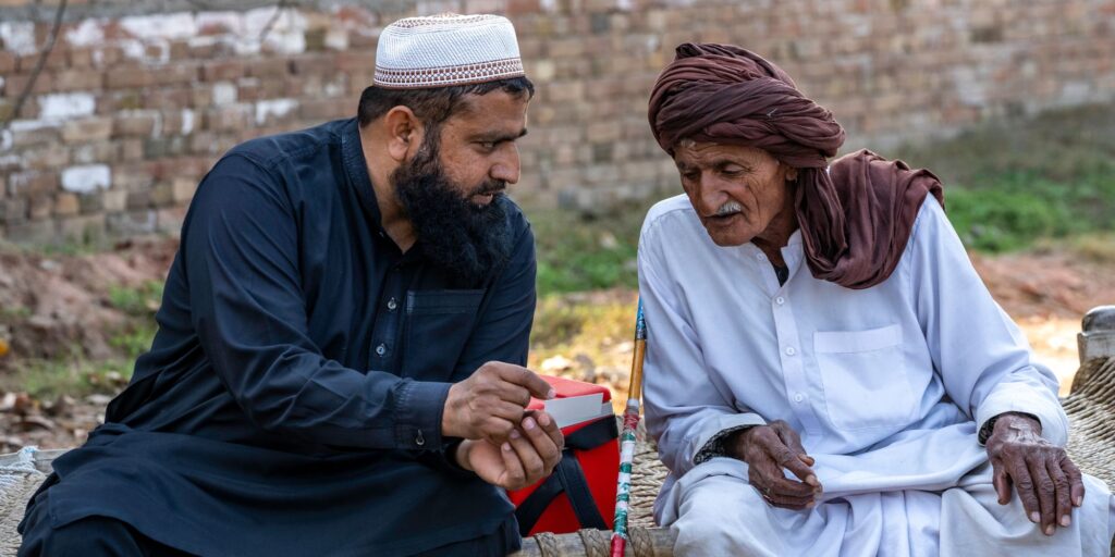 Agricultural officer, Muhammad Farooq explains how to use the card to a farmer