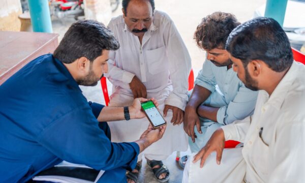A group of farmers in Pakistan being shown the Crop Sprayer app