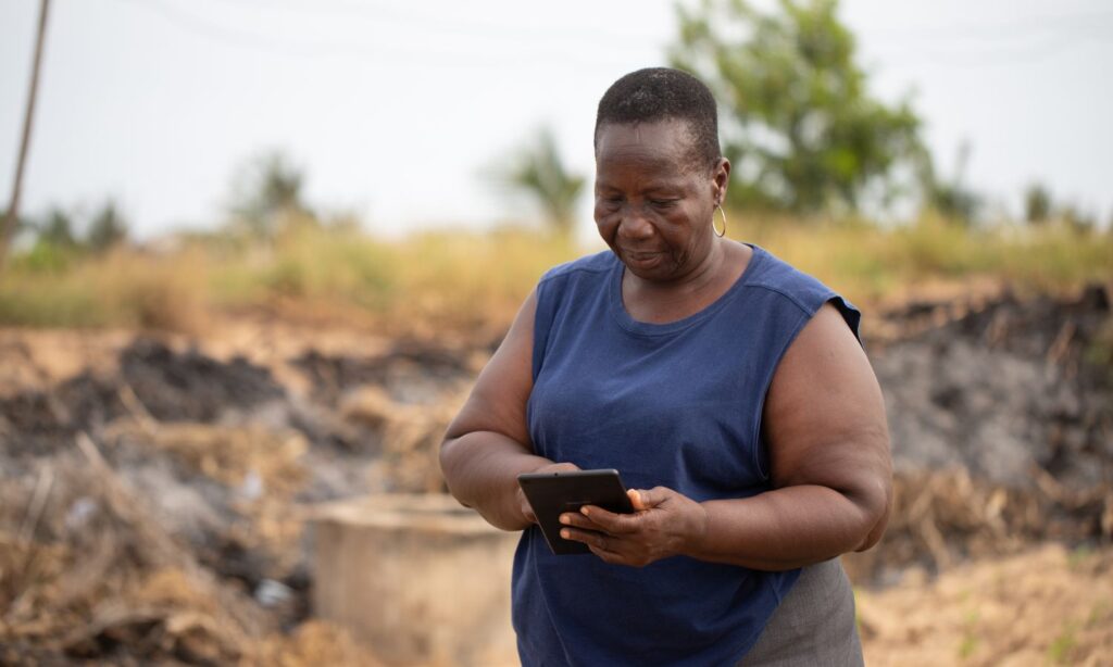 A farmer in Ghana using AI digital tools in her field