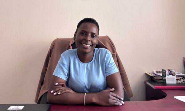 Mercy, a crop scientist from Kenya, sitting at her desk