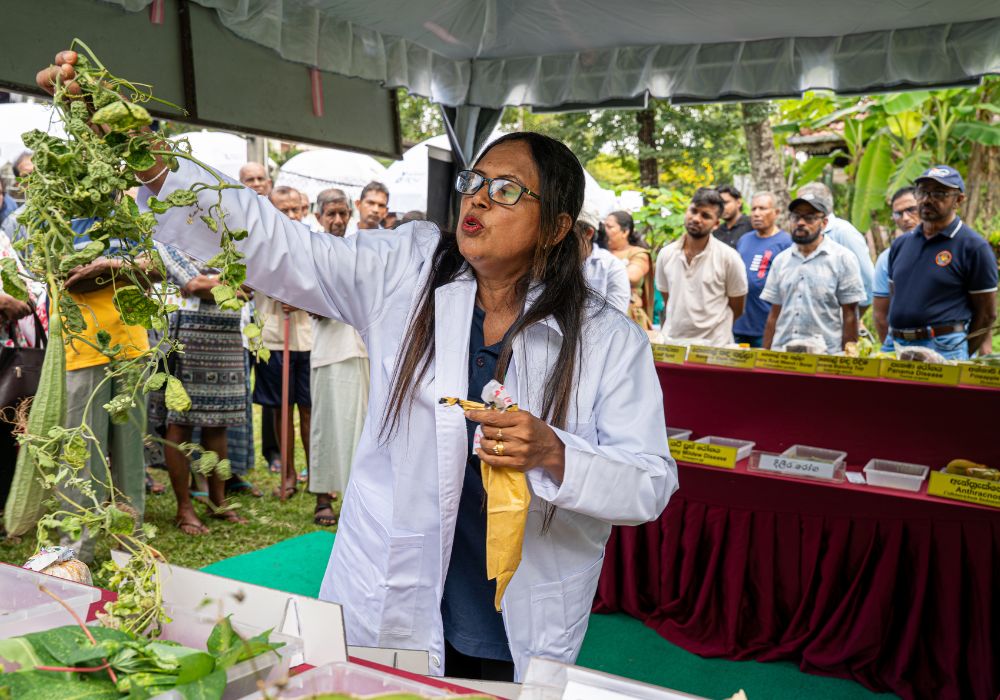 A plant doctor shows a gourd specimen while giving a talk at a plant clinic in Kandy